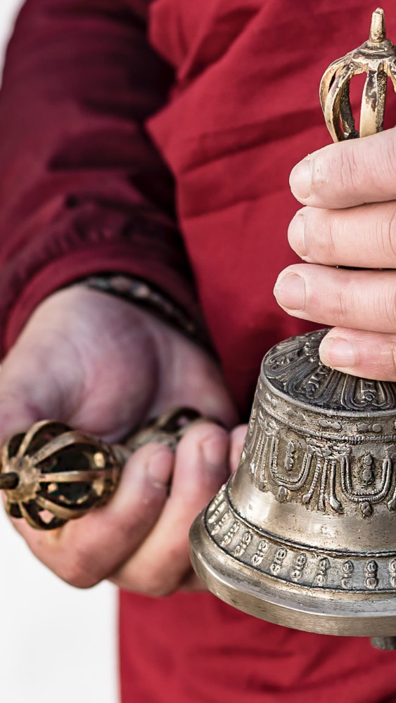 amankora, bhutan accommodation, thimphu lodge, monk with dorji (thunderbolt) and drilbu (bell) during chorten courtyard sungkey blessing