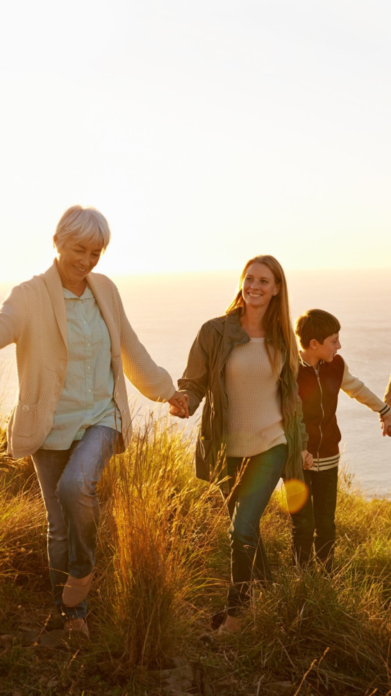 family,teamwork.,a,multi generational,family,walking,up,a,grassy,hill